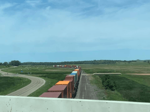 A long train going underneath the bridge